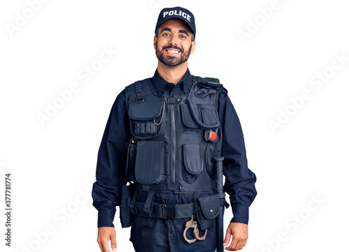 Young hispanic man wearing police uniform with a happy and cool smile on face. lucky person.