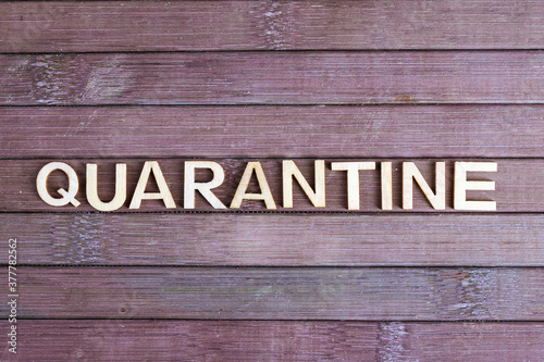 Quarantine - word made from wooden letters, not wooden background. Isolation to prevent infection. Quarantine concept.