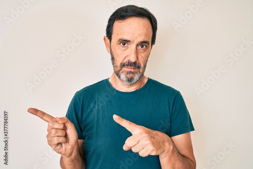 Εκτύπωση καμβά Middle age hispanic man pointing with fingers to the side relaxed with serious expression on face