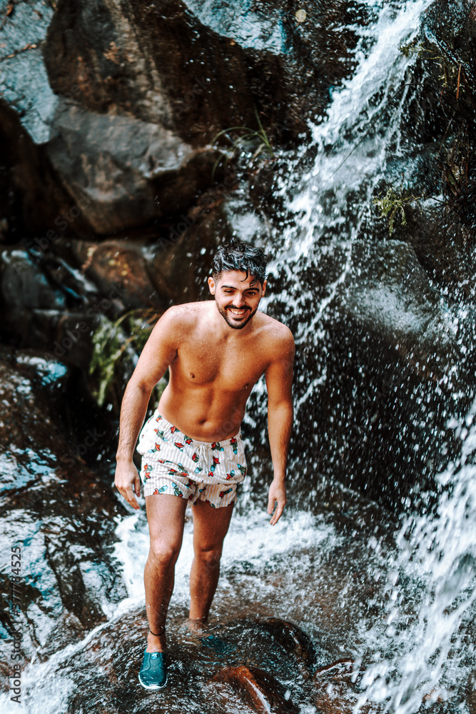 Joven atractivo en cascada mojandose Joven atractivo en cascada mojandose