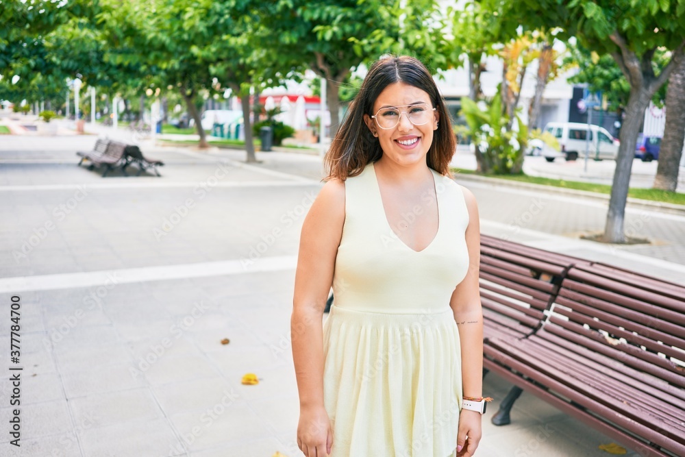 Young beautiful woman smiling happy. Standing with smile on face looking at the camera walking at town street.