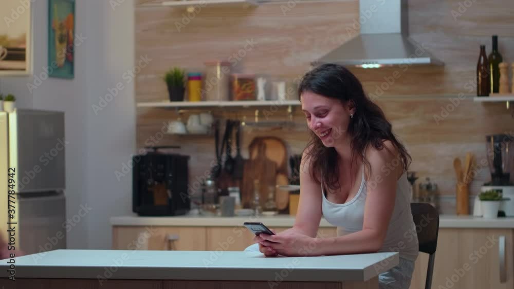 Unfaithful wife chatting near husband at home. Jealousy desperate man cheated, angry, frustrated and irritated, finds messages of infidelity on the woman's phone sitting in the kitchen. Unfaithful wife chatting near husband at home. Jealousy desperate man cheated, angry, frustrated and irritated, finds messages of infidelity on the woman's phone sitting in the kitchen.