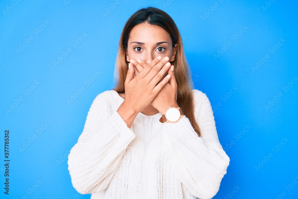 Young brunette woman wearing casual sweater shocked covering mouth with hands for mistake. secret concept. Young brunette woman wearing casual sweater shocked covering mouth with hands for mistake. secret concept.