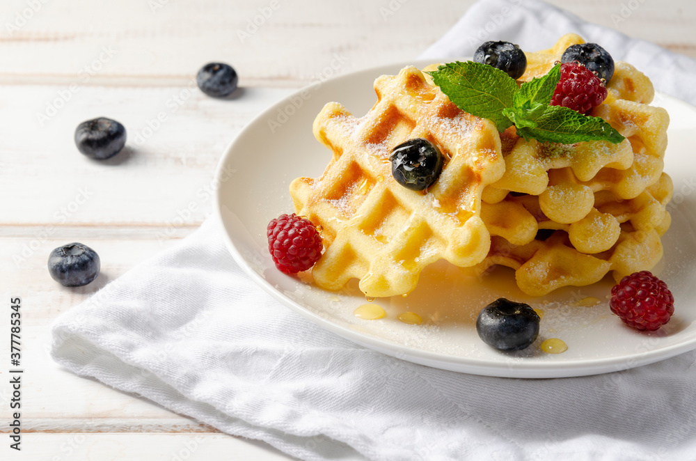 Waffles with fresh blueberries for breakfast on white table Waffles with fresh blueberries for breakfast on white table