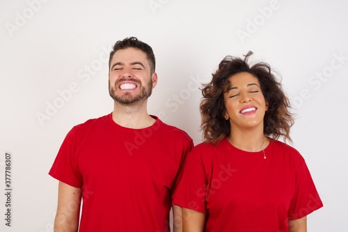 Young beautiful couple wearing red t-shirt on white background very happy and excited about new plans. © Roquillo