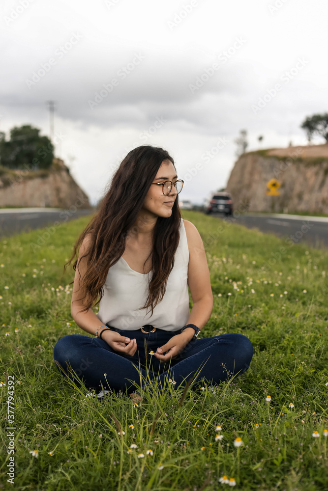 Young woman sitting on a rock in nature Young woman sitting on a rock in nature