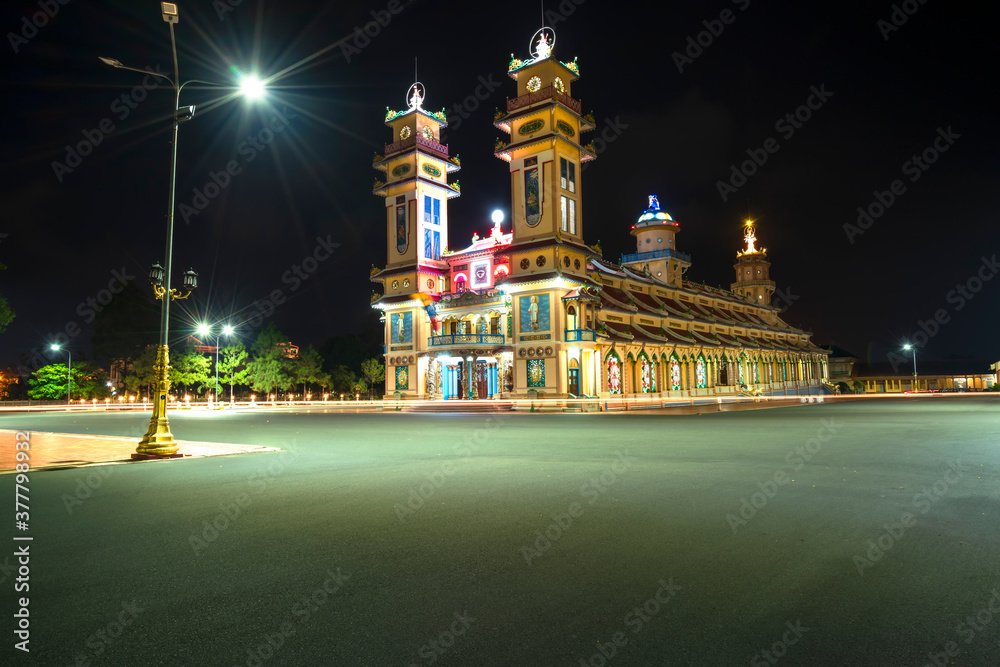 Obraz premium Landscape outside holy temple in night was built in 1926, the temple is turned on at night to pray on the 1st of the holiday season in Tay Ninh, Vietnam