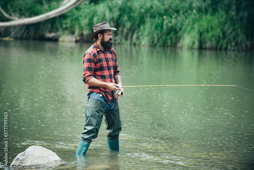 Portrait of cheerful bearded man fishing. Fun and relax. Fly fishing adventures. Hobby and sport activity. Portrait of man on holiday. Fisherman fishing equipment. Handsome man relaxing.