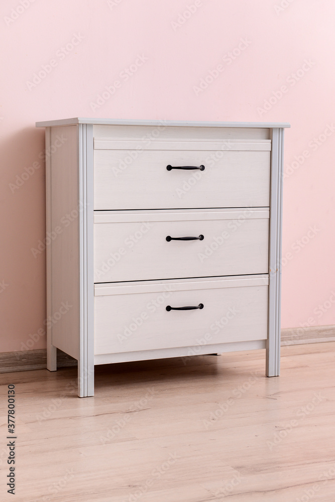 Modern chest of drawers near color wall in room