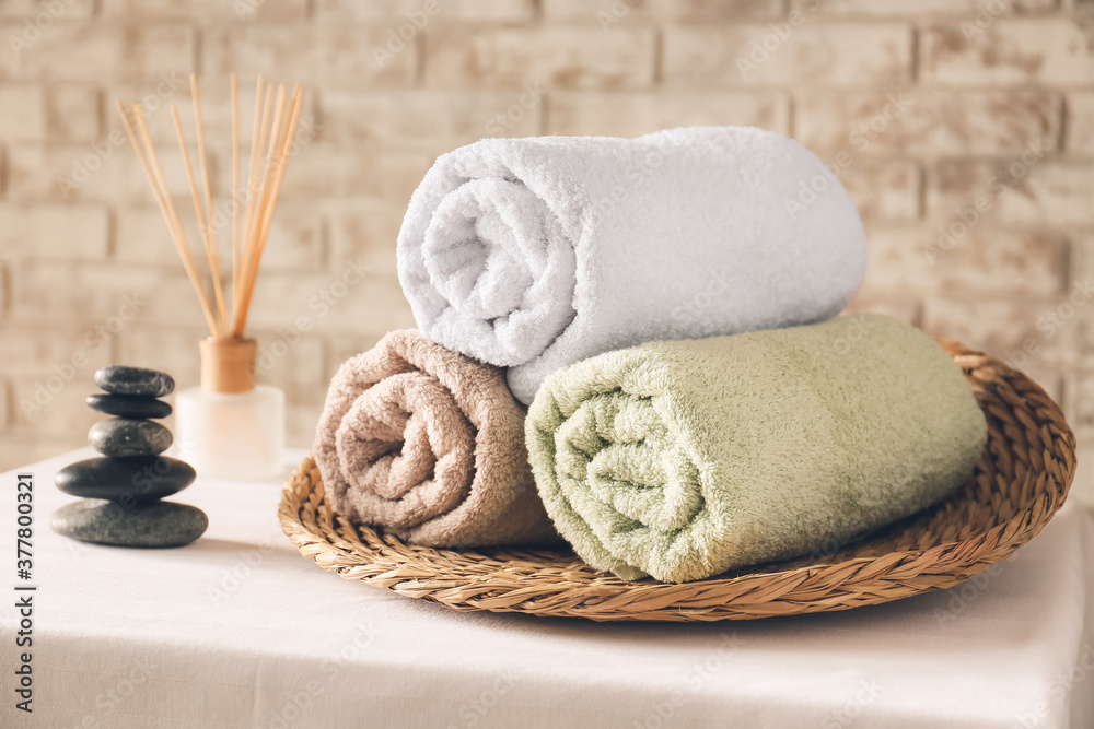 Wicker tray with clean towels on table Wicker tray with clean towels on table