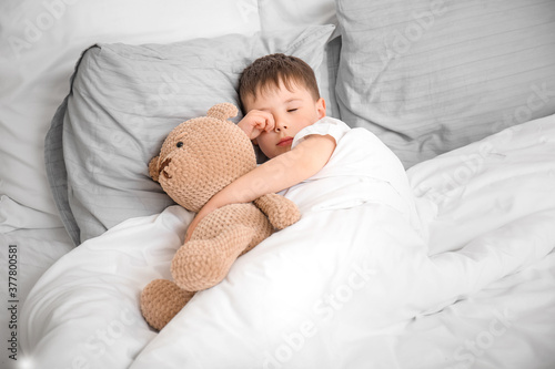 Little boy suffering from sleep disorder in bedroom photo