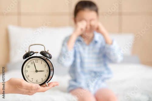 Mother with alarm clock in ...
