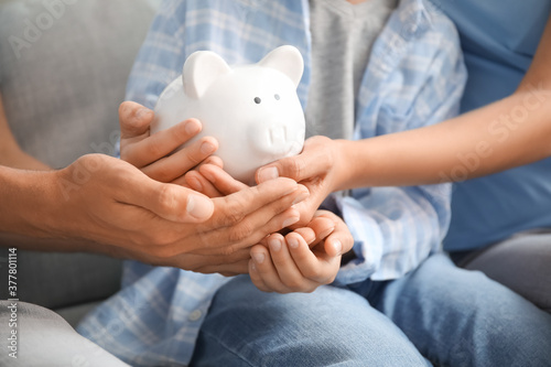 Family with piggy bank at h...