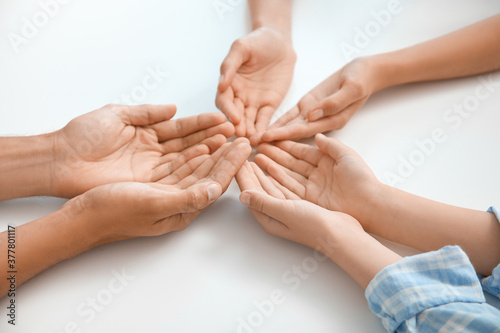 Hands of family on white ba...