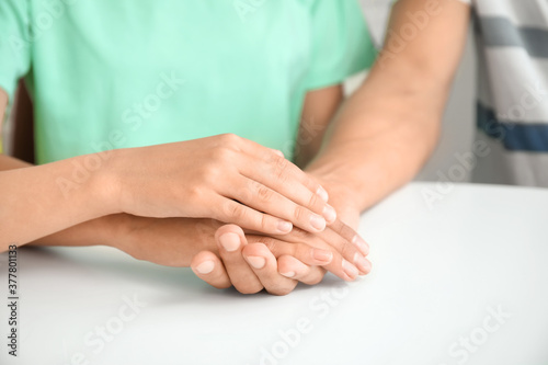 Family holding hands together at table  closeup