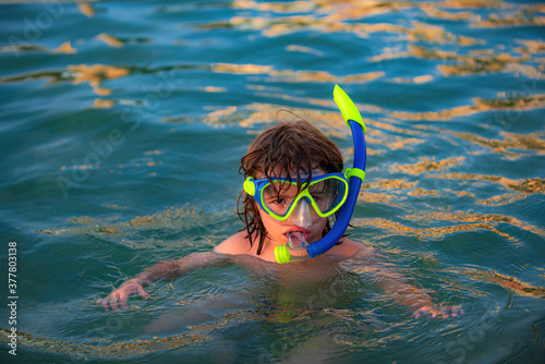 Happy child playing in the sea. Kid snorkeling in the ocean.