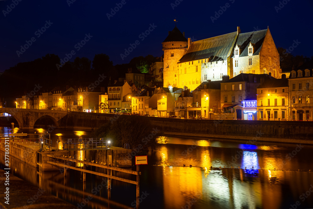 Night view across Mayenne river of French town of Laval overlooking illuminated medieval Chateau in summer