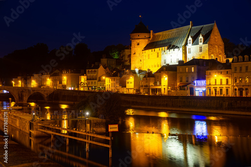 Night view across Mayenne river of French town of Laval overlooking illuminated medieval Chateau in summer