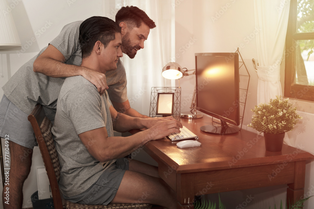 Happy married LGBT couples work together with love and romantic moment in family home office Happy married LGBT couples work together with love and romantic moment in family home office
