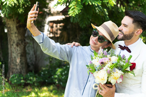 Young married LGBT couples selfie a romantic wedding moment together with love