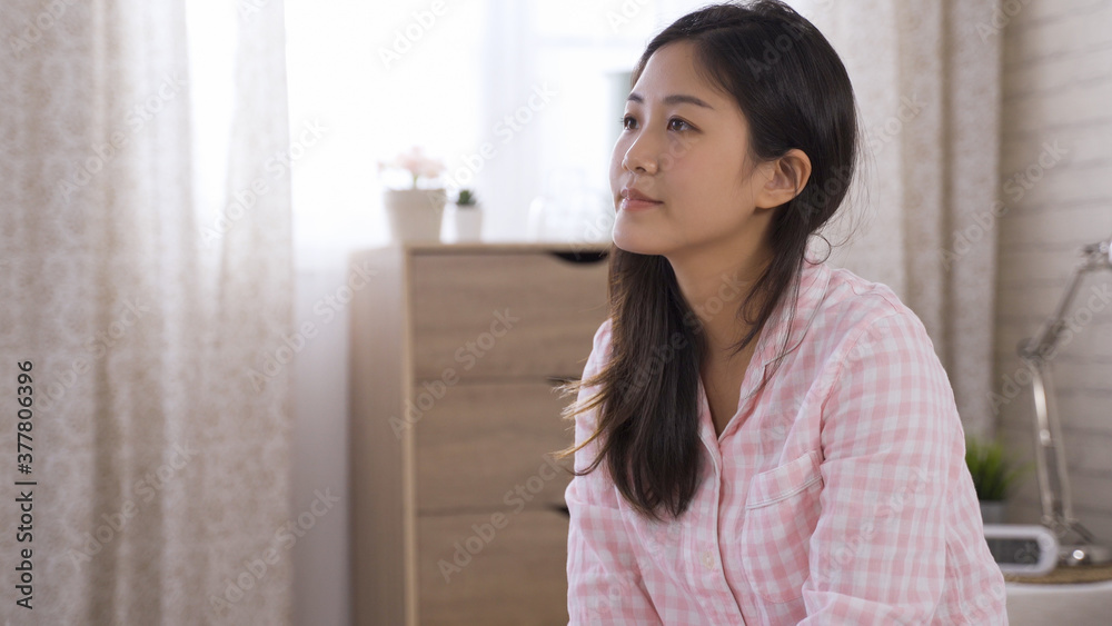 portrait of charming korean young female feeling contented with living single and enjoying holiday morning in modern bedroom alone. portrait of charming korean young female feeling contented with living single and enjoying holiday morning in modern bedroom alone.