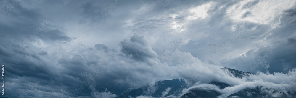 Landscape of very cloudy sky and mountains over lake Como, which is located in Northern Italy.