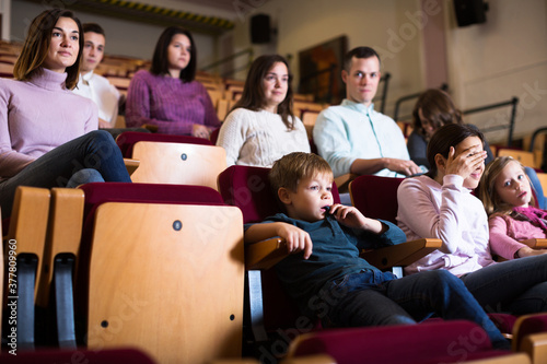 Group of people watching exciting movie in cinema house