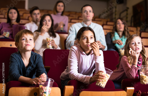 Group of people eating popcorn during film in cinema
