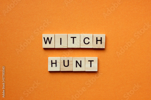 Words Witch Hunt. Wooden blocks with an inscription on an orange background. Bulletin board. The concept of the holiday is Halloween. The view from the top. Copy space