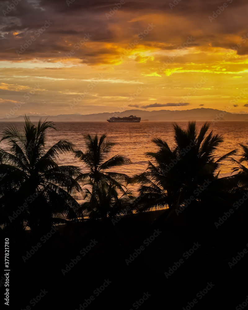 Beautiful aerial view of the majestic sunset with palm trees, ocean and cruise ships in Costa Rica 