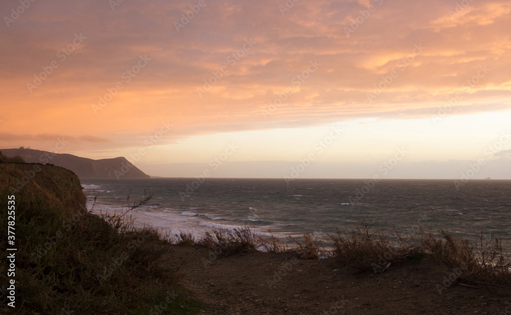 Beautiful seascape view. Sunset sky with sea, pastel colors. Mountains landscape and seacoast. High view to ocean coast waves. Soft focus