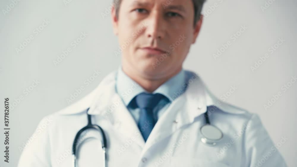 selective focus of doctor in white coat breaking cigarette on grey selective focus of doctor in white coat breaking cigarette on grey