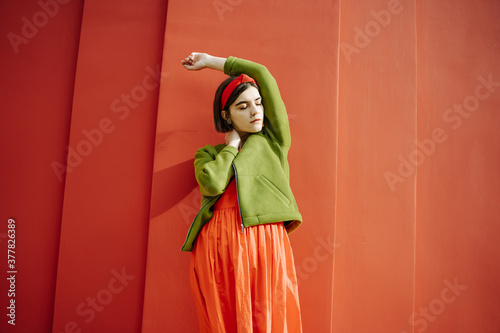 in love mood. Closed eyes beautiful young girl portrait. Stylish color combination with red dress and green jacket. dreamy stylish trendy young girl in stylish clothes combination bright saturated 