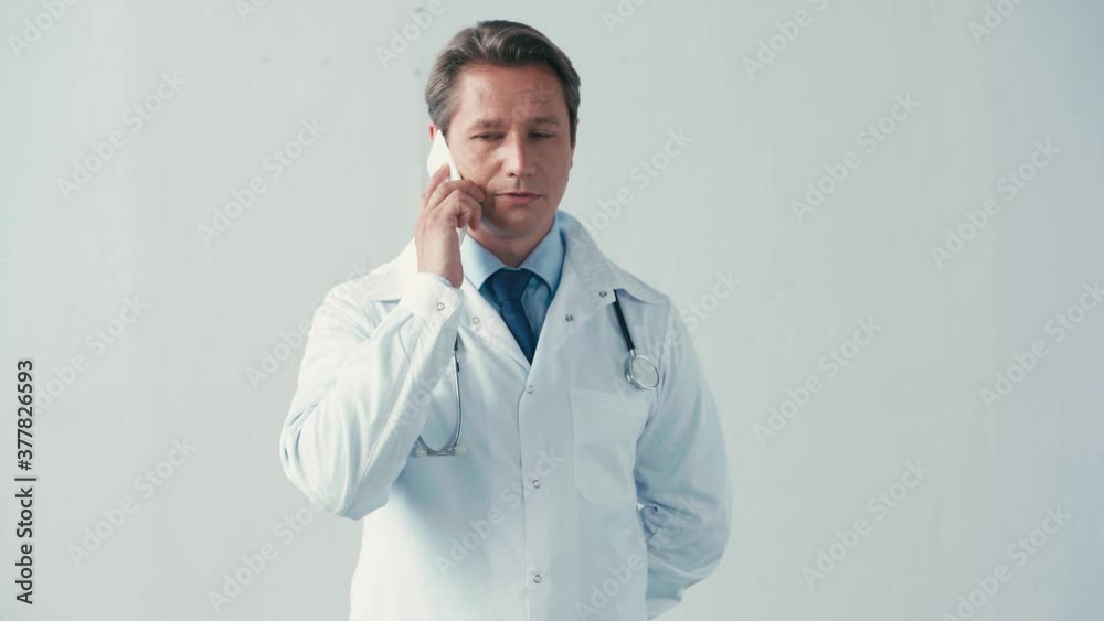 doctor in white coat talking on smartphone on grey doctor in white coat talking on smartphone on grey