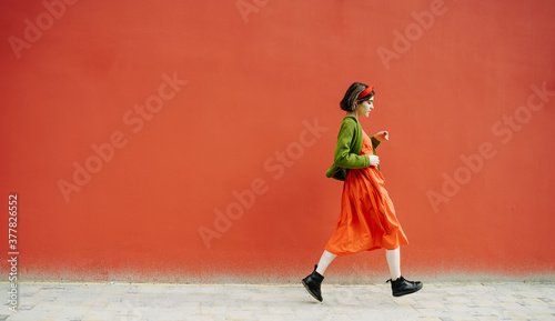 Billede på lærred beautiful active running fancy young girl on red background