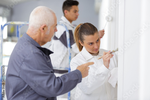 female commercial painter painting door frame