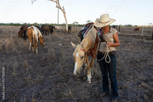 Fotomurale Young female drover caring for her horse.