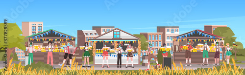 people in masks drinking beer octoberfest party celebration open air outdoor festival cityscape background full length horizontal vector illustration