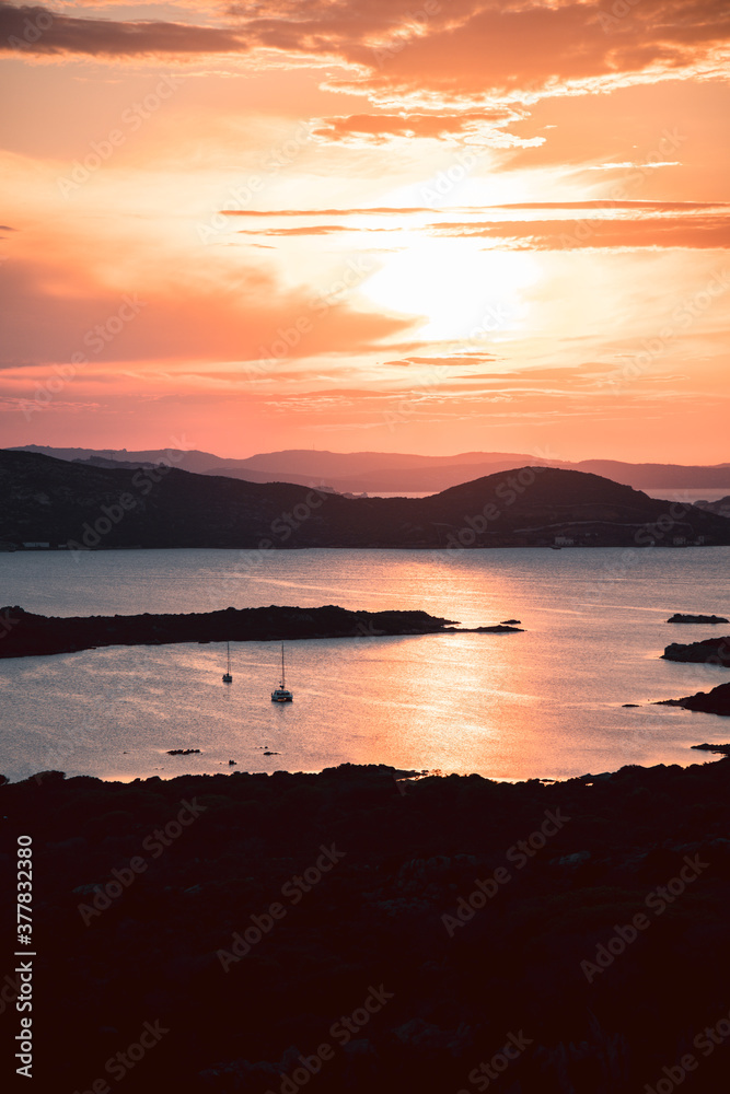 Beautiful sunset over the La Maddalena archipelagos, in Sardinia, Italy, from the natural reserve of Caprera Island. Sunset over water, sun reflections, unique sky.