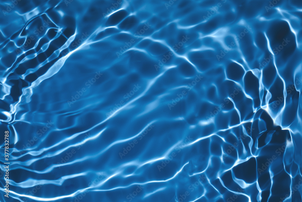 Blurred transparent dark blue colored clear calm water surface texture with splashes and bubbles. Trendy abstract nature background. Water waves in sunlight with copy space. Blurred transparent dark blue colored clear calm water surface texture with splashes and bubbles. Trendy abstract nature background. Water waves in sunlight with copy space.