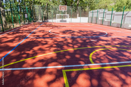 Outdoor sports field with red shock absorbing coating in park photo