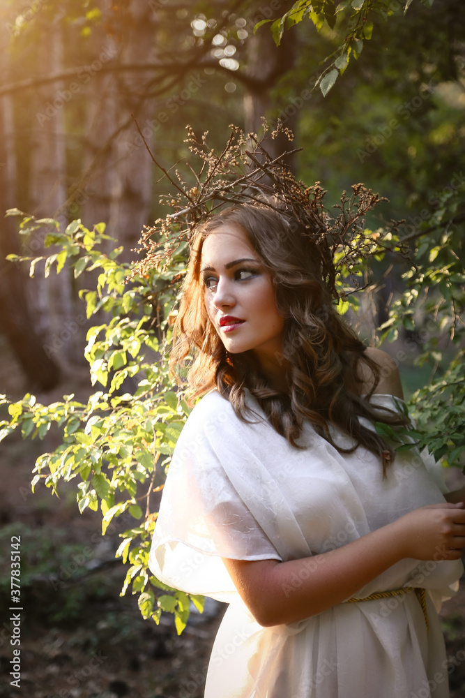 Beautiful mystery gothic woman in long white dress in autumn forest.