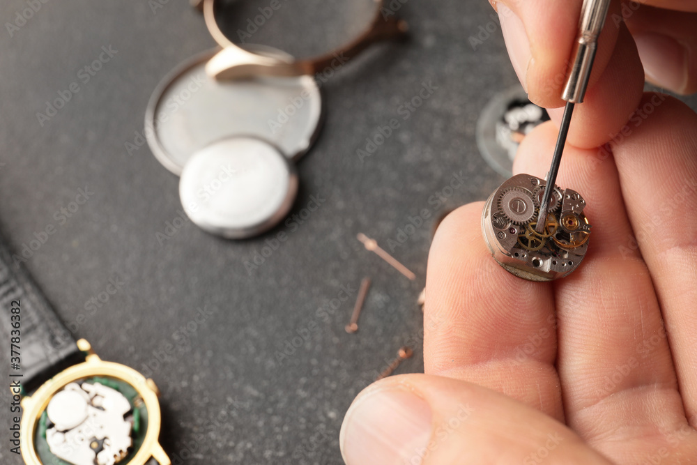 Clockmaker repairing broken watch at table, closeup Clockmaker repairing broken watch at table, closeup