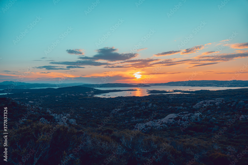 Beautiful sunset over the La Maddalena archipelagos, in Sardinia, Italy, from the natural reserve of Caprera Island. Sunset over water, sun reflections, unique sky.