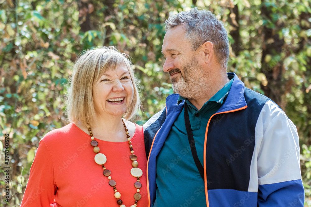 Portrait of beautiful senior couple relaxing in the autumn park