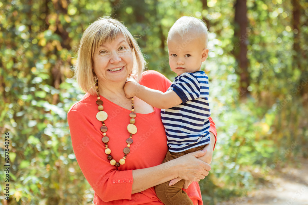 Happy grandma with grandson embracing outdoor Happy grandma with grandson embracing outdoor