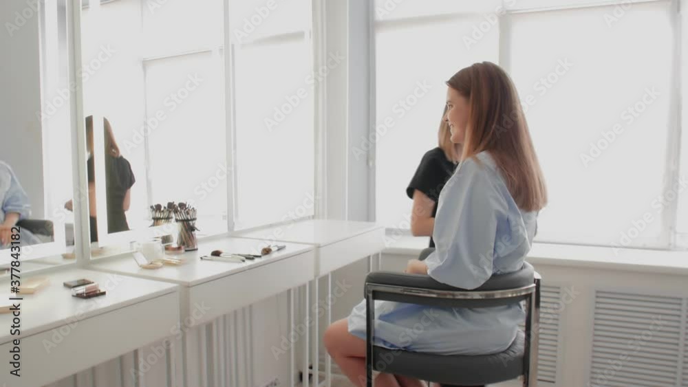 Adult makeup artist finished her work and leave away while young model enjoying her make up Adult makeup artist finished her work and leave away while young model enjoying her make up