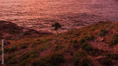beautiful sunset on green grass coastline 4k time lapse, laem krating viewpoint at Phuket Thailand 