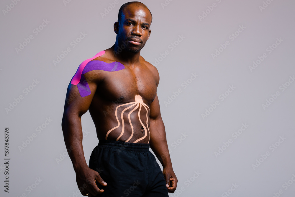 Male athlete African American with kinesio tape on the abdominal