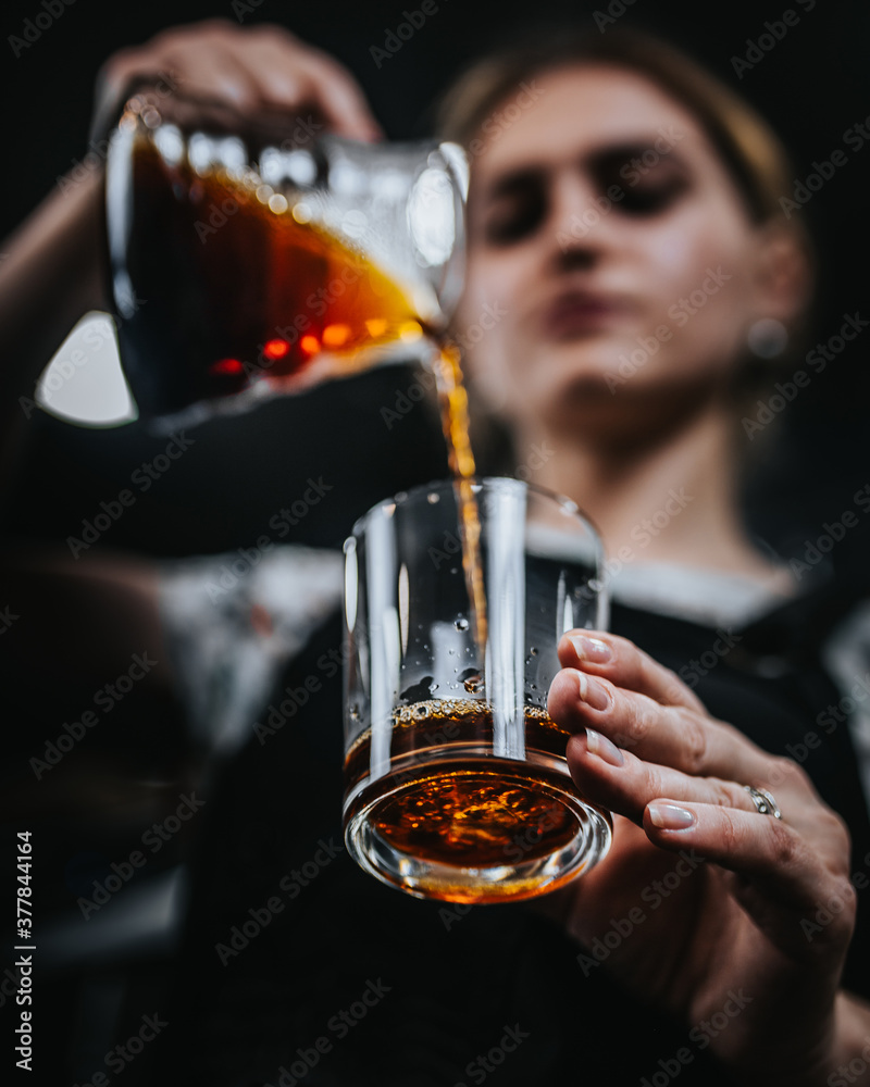 Barista girl pouring coffee into glass focus on glass bottom view